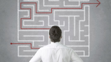 Man searching for a nonprofit accounting cheat sheet in a maze