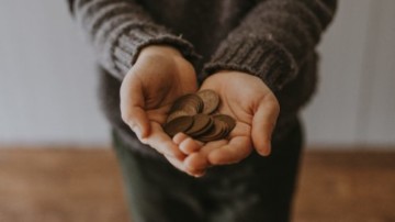 Hand holding pennies.