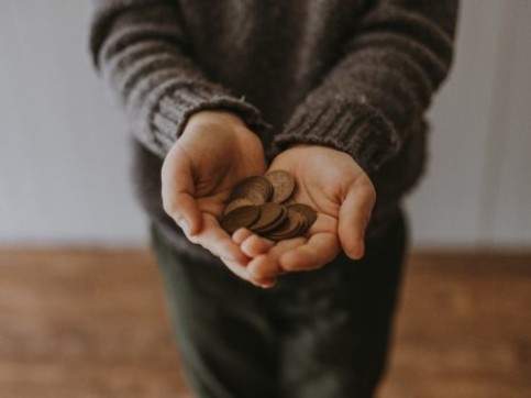 Hand holding pennies.