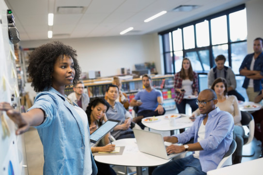 Woman leading a meeting, going through the fundraising event planning checklist