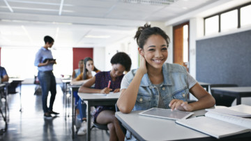 Female student smiling to camera in classroom.