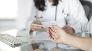 Cropped view of doctor handing patient prescription