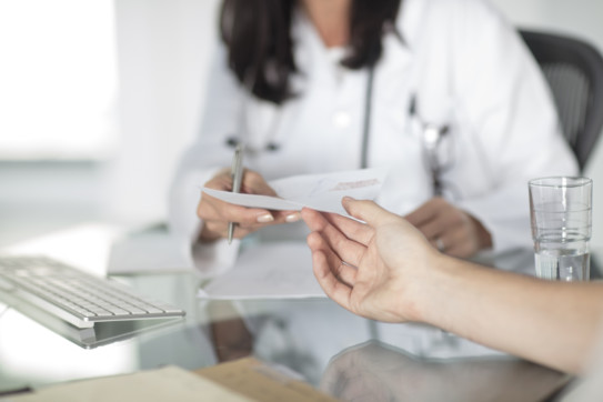 Cropped view of doctor handing patient prescription