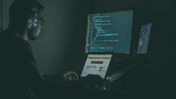 Man in the dark coding in front of a computer.