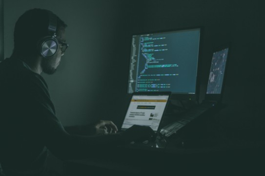 Man in the dark coding in front of a computer.