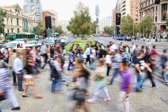 a large group of people crossing a city crosswalk