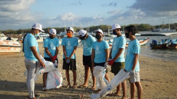 A group of volunteers waiting to clean up the beach.